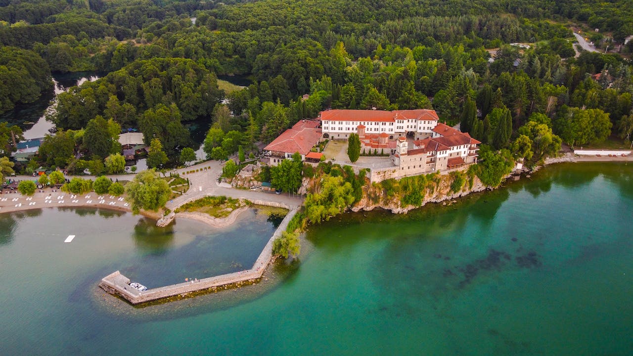 image source Photo by Micko Damnjanovski: https://www.pexels.com/photo/aerial-view-of-the-monastery-of-saint-naum-at-ohrid-lake-9521496/